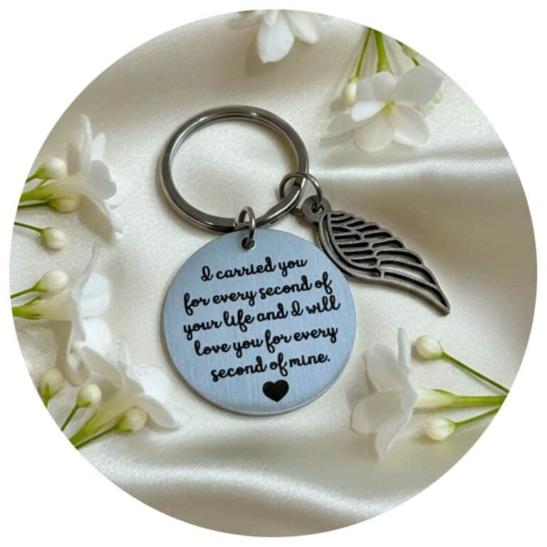 sleutelhanger met engelvleugel omringd door witte bloemen